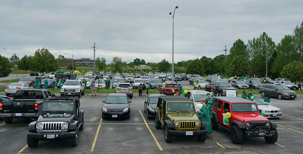 Vehicles with various decorations sit in the parking lot prior to the start of the parade